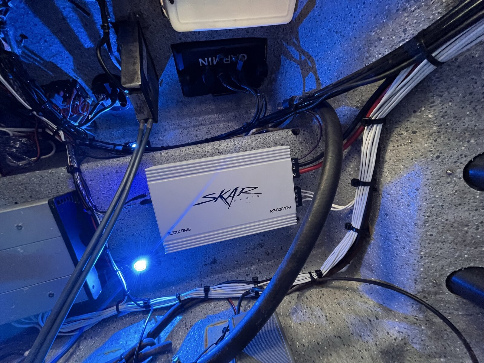 Skar marine amplifier installed in a clean rigging compartment with Garmin electronics and LED lighting
