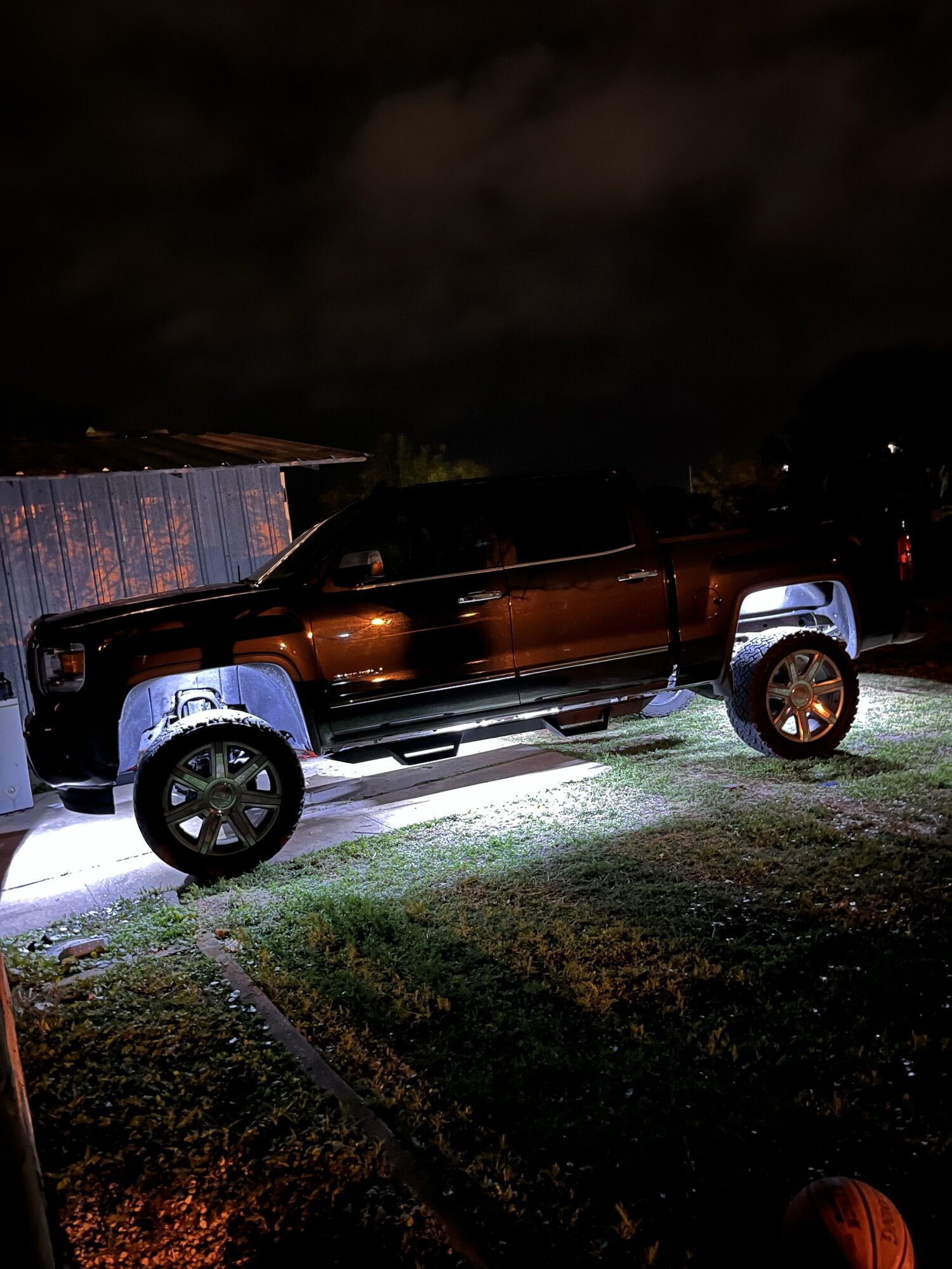 Blacked-out lifted GMC Sierra with custom underglow lighting