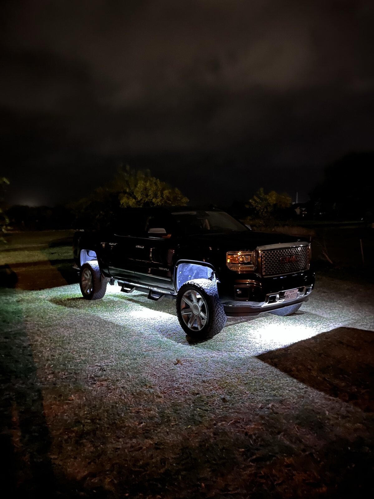 GMC Denali at night with rock-light underglow